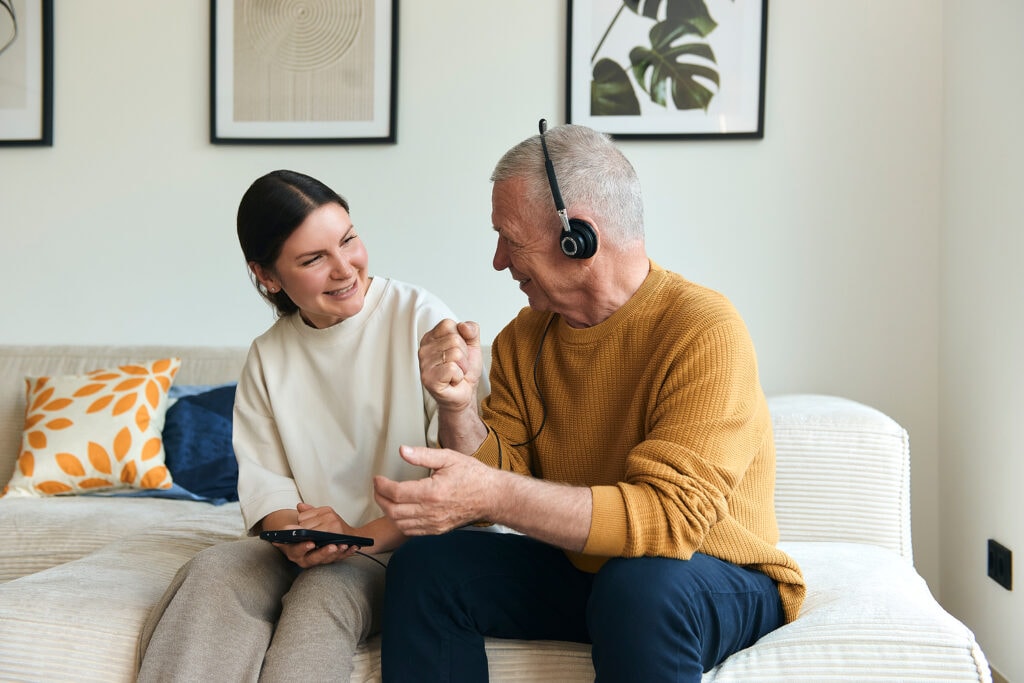 Pflegehelferin und Kunde beim gemeinsamen Musikhören