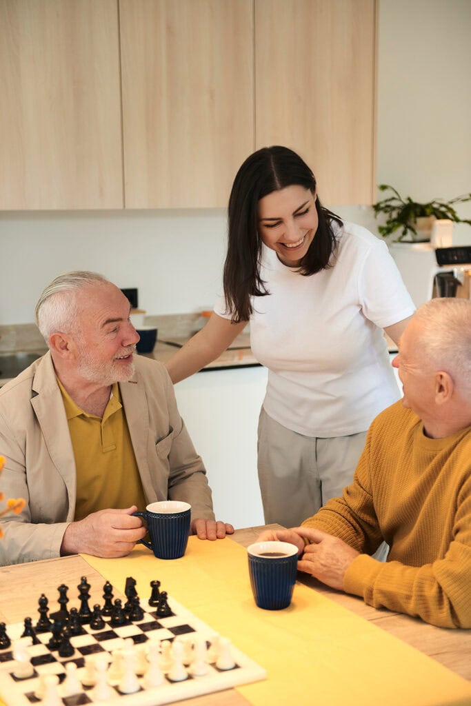 Gemeinsame Freizeitaktivitäten umfassen Spielen und Teetrinken mit Unterstützung der Pflegehilfskraft