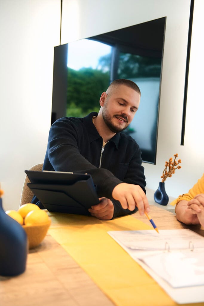 Kundin und Pflegedienstleitung gehen die Unterlagen gemeinsam durch und unterschreiben den Pflegevertrag zusammen